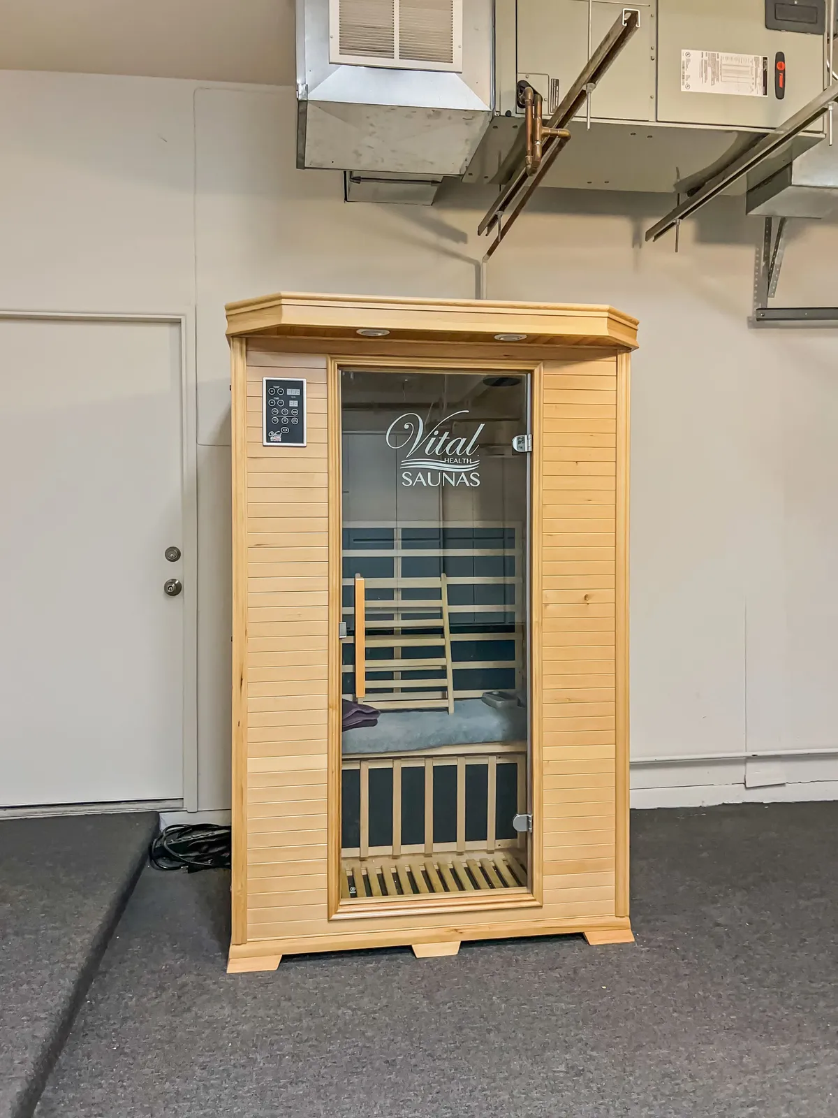 This interior image focuses on the well-appointed sauna unit, complete with a control panel and comfortable bench seating, inviting guests to enjoy a soothing wellness experience indoors.